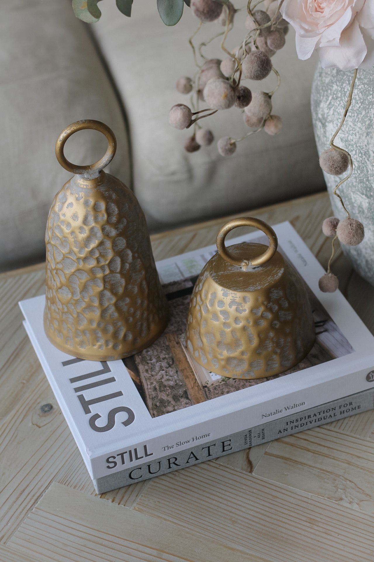 pair of bronze decorative bells styled on a coffee table
