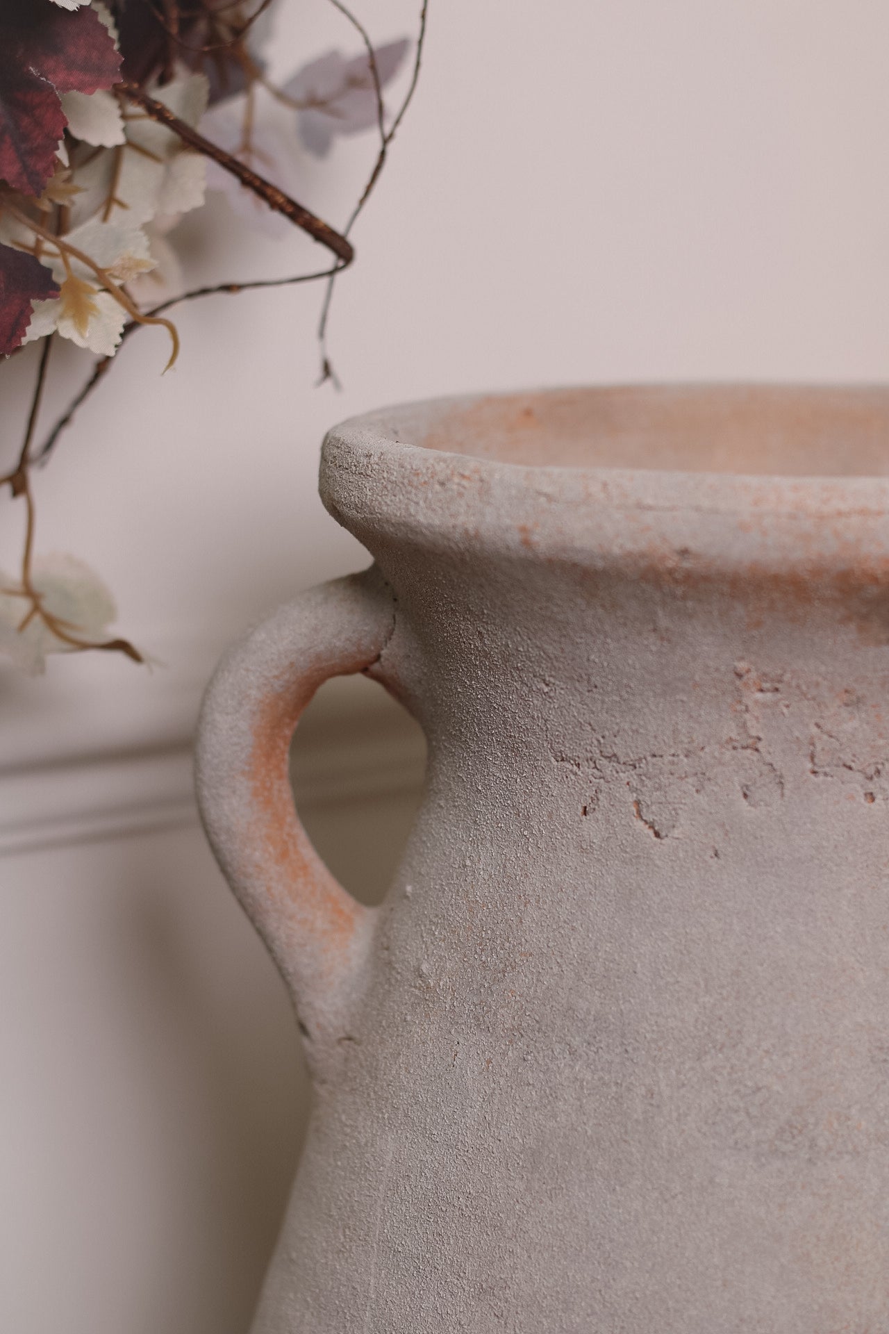 up close of rustic terracotta vase with handles