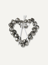 A heart-shaped metal wreath decoration made of small silver bells tied together with a white ribbon, shown on a plain off-white background.