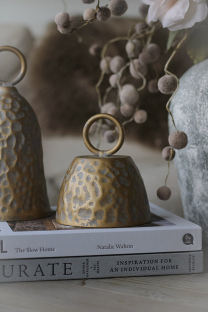 small cloche decorative rustic bronze bell styled on a pile of books