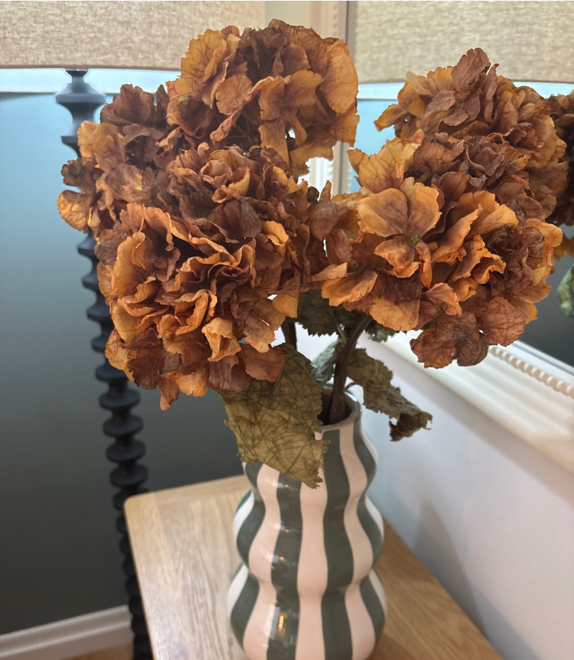 Faux honey dried ruffle hydrangea stems in striped wave ceramic vase