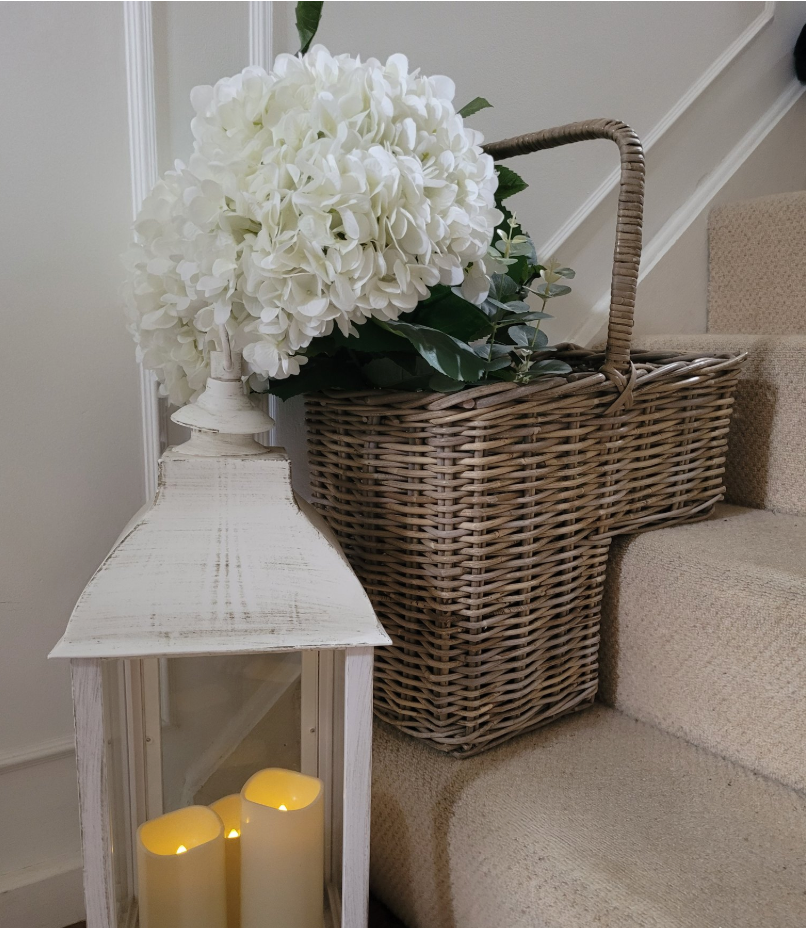 grey washed rattan stair basket with faux white hydrangea and distressed lantern