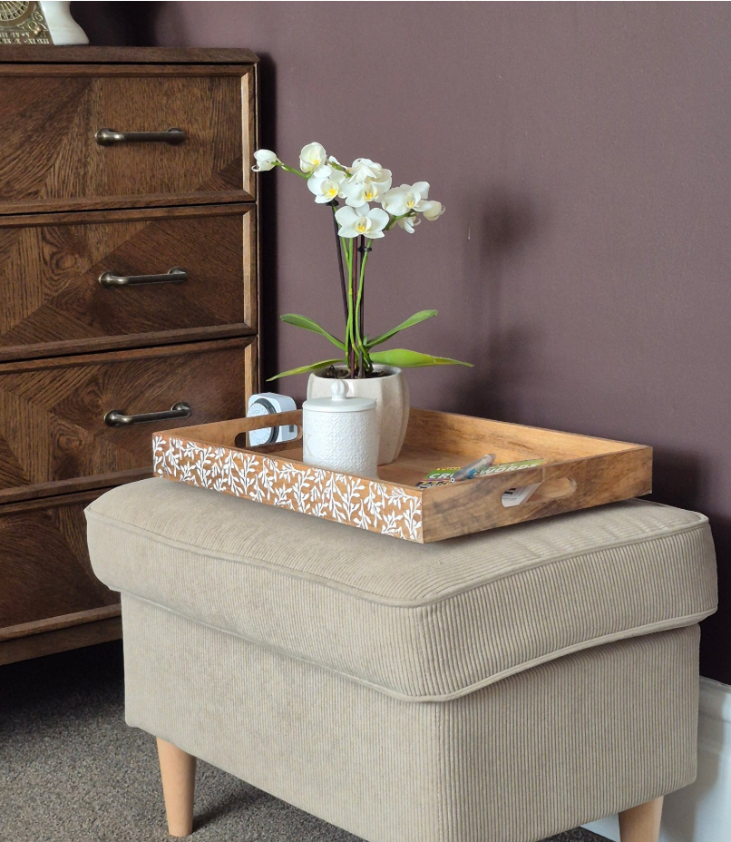 Floral etched mango wood tray styled on ottoman