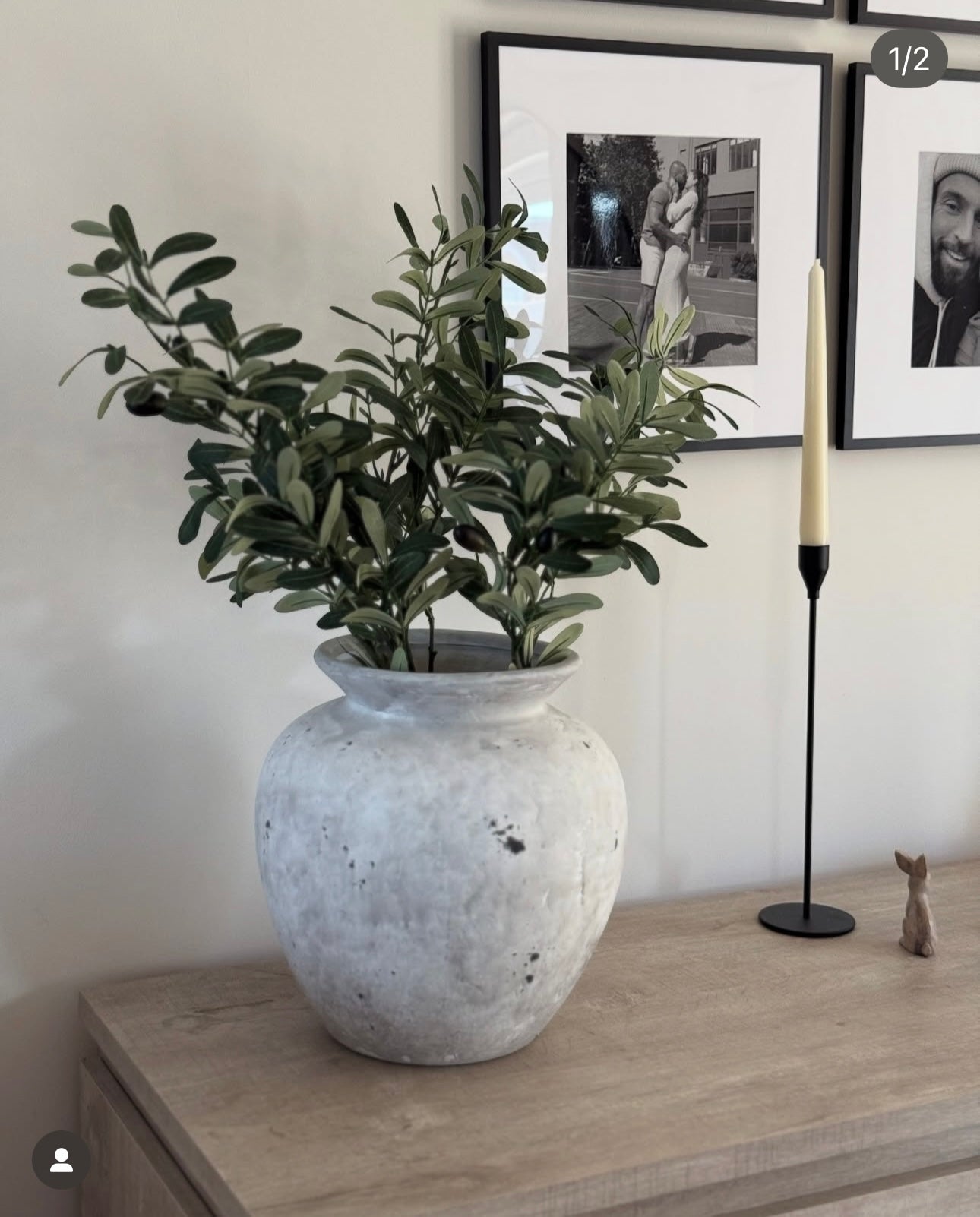 Grey rustic stone vase styled with faux olive stems on sideboard. Beautiful idea for home decor
