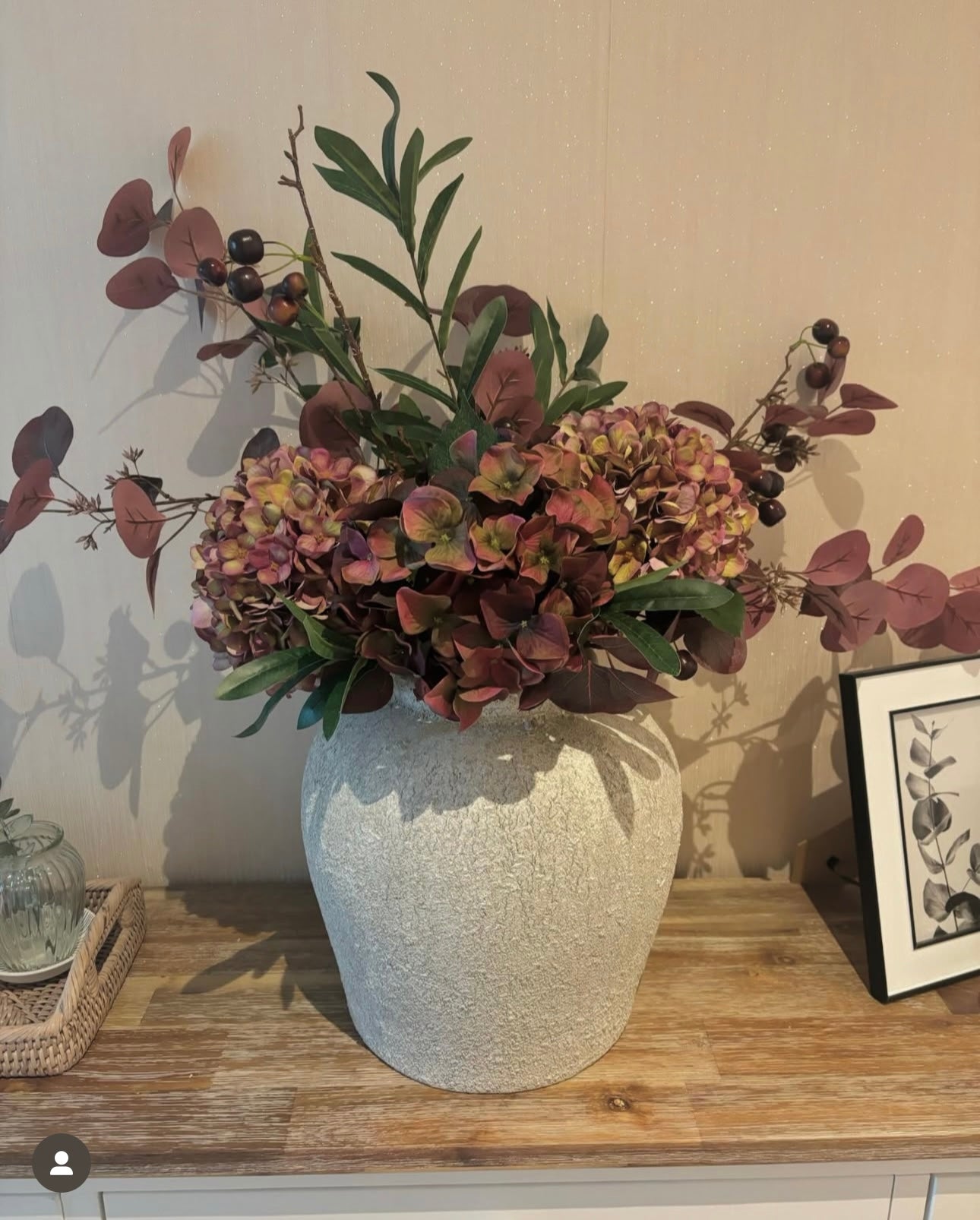 Rustic stone vase filled with faux mulberry hydrangeas, burgundy eucalyptus and faux cherry stems