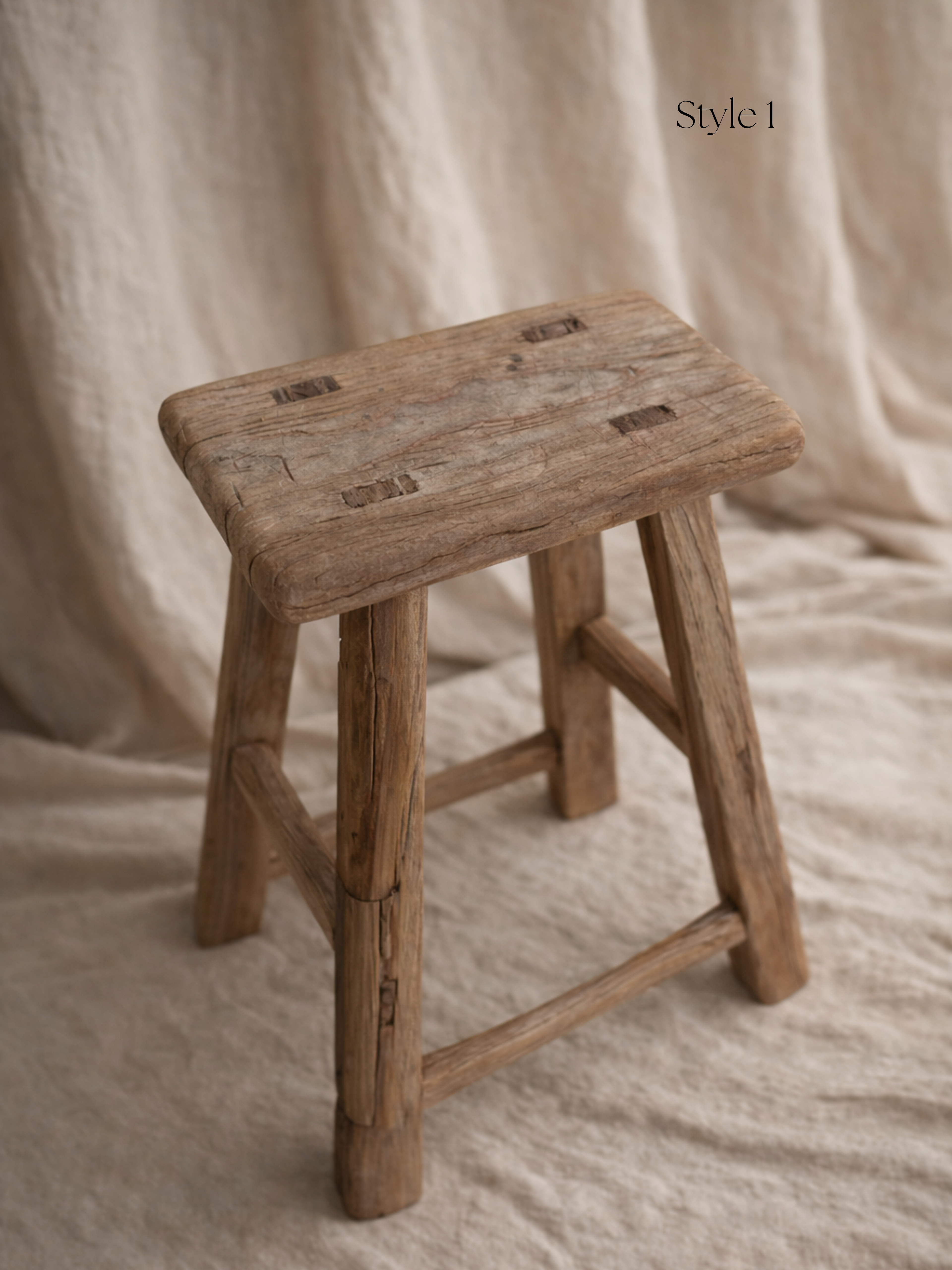 Wooden stool with a rustic design on a beige fabric background for home decor