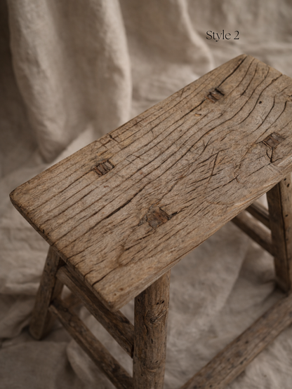 Vintage wooden stool with a textured surface on a neutral background for home decor