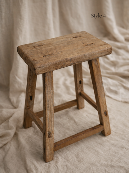 Vintage wooden stool on a textured beige background for home decor