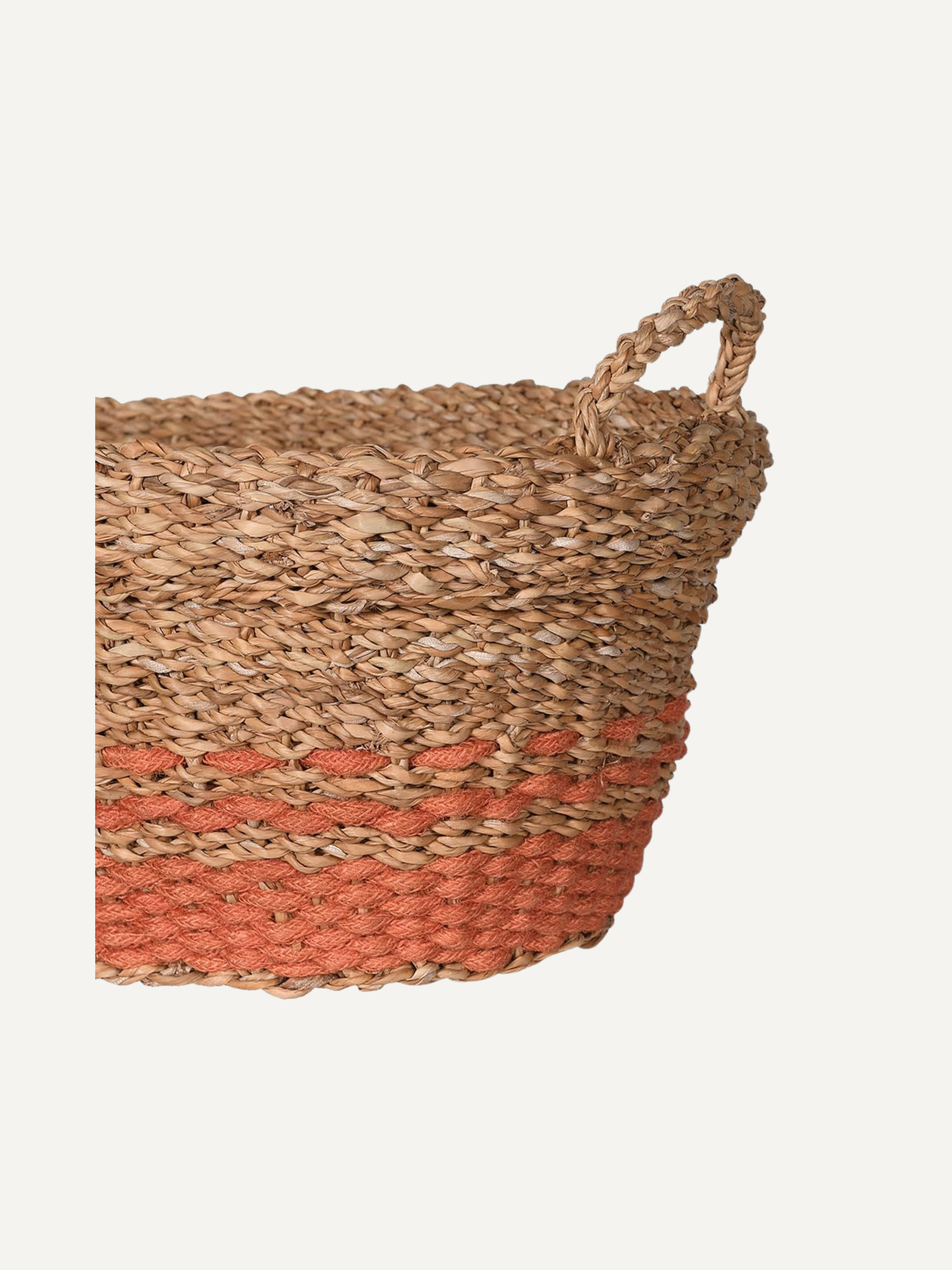 Woven basket with a orange rust stripe on a light background