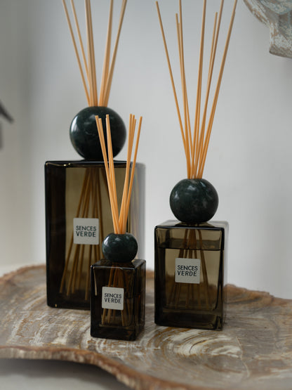 three green glass reed diffusers with dark green marble spheres and natural wood reeds, labeled &