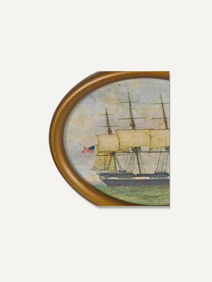 An oval framed vintage-style painting depicting a three-masted sailing ship with a small American flag, shown against a plain light background.